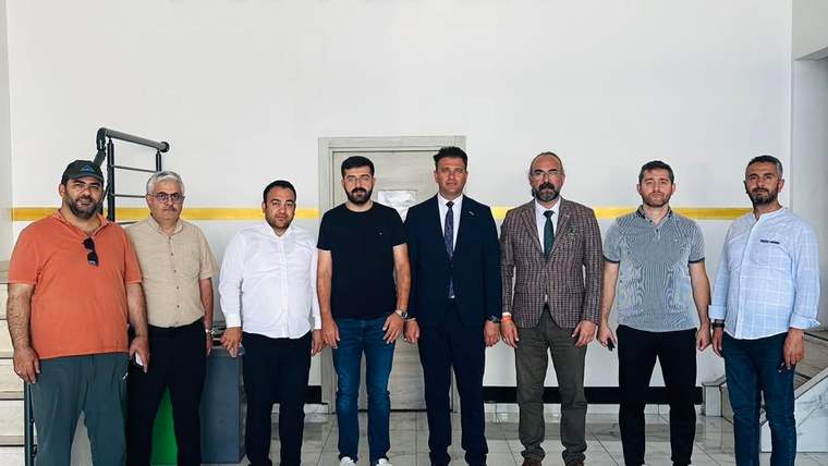 Argüp Yalıtım binasında, MÜSİAD Sivas üyeleriyle bir grup insan poz veriyor.