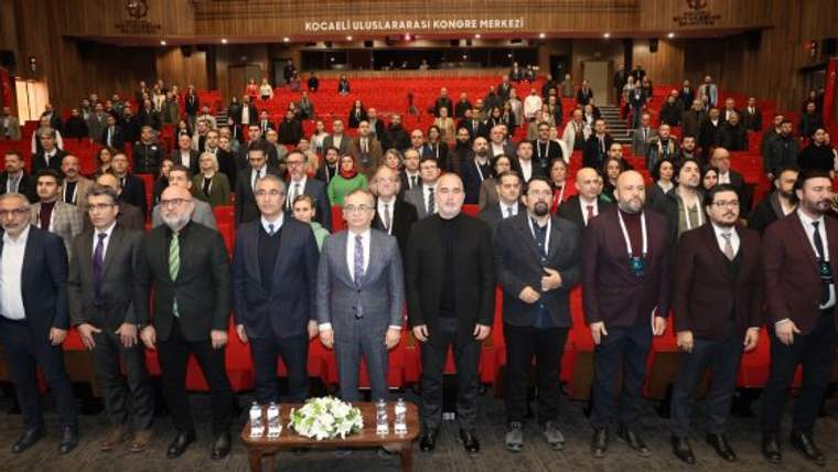 Kocaeli Uluslararası Kongre Merkezi salonunda, ön sırada duran kalabalık bir grup birlikte poz veriyor.