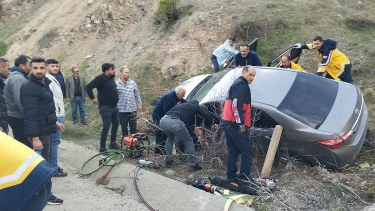 Kaza sonrası otomobilin etrafında toplanmış insanlar, kurtarma çalışmaları yapıyor.