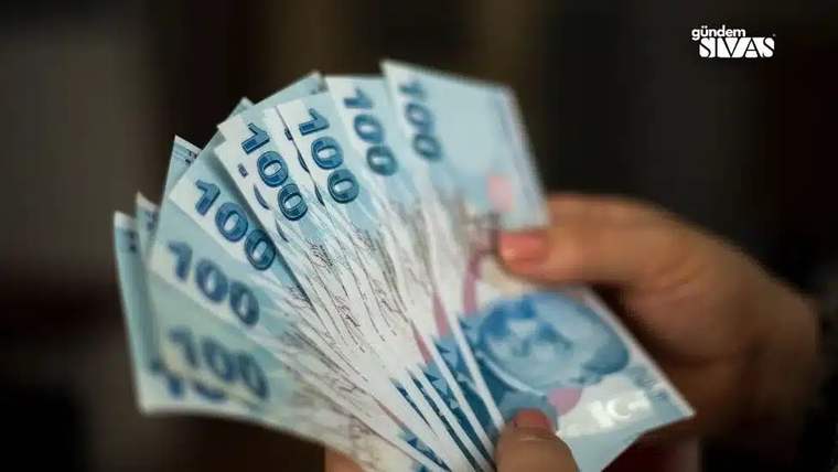 Bir kişinin elinde, 100 TL banknotlardan oluşan bir deste para bulunuyor.