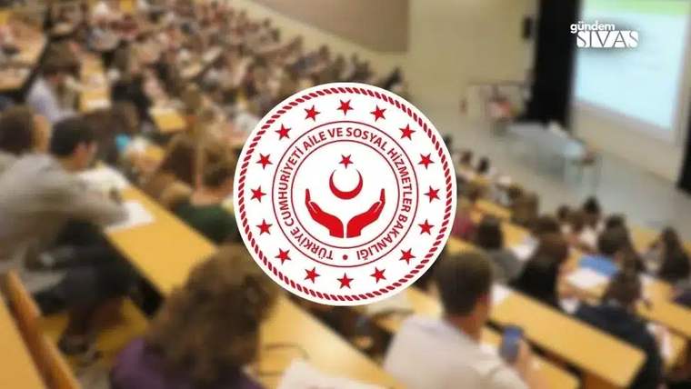 Büyük bir konferans salonunda oturan kalabalık bir izleyici grubu, sahnede bir sunum izliyor.