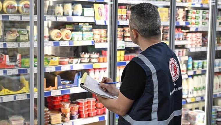 Bir denetçi, süpermarket raflarında ürünleri kontrol ediyor ve not alıyor.