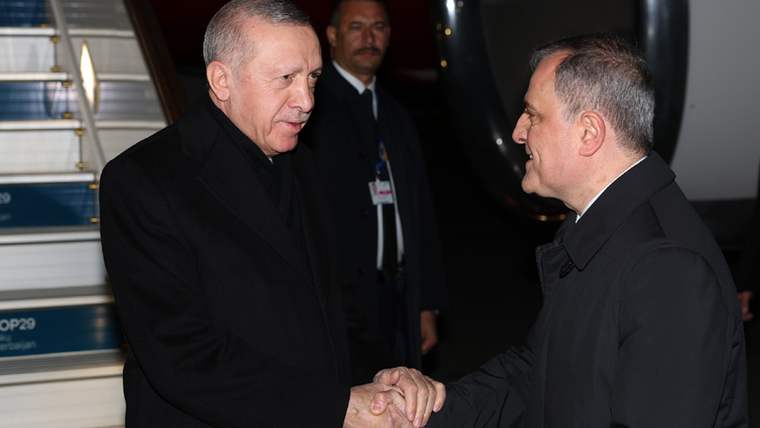 Cumhurbaşkanı Erdoğan, Bakü'de bir kişiyle tokalaşıyor.