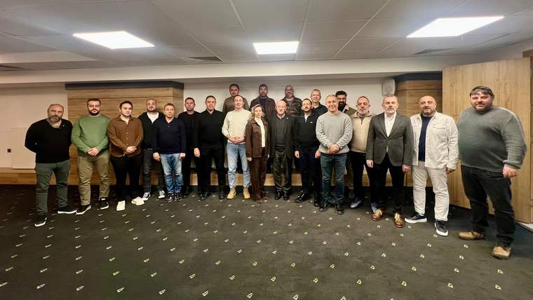 Bir otelde toplanmış, erkek ve kadınlardan oluşan bir grup insan, fotoğraf çekiliyor.