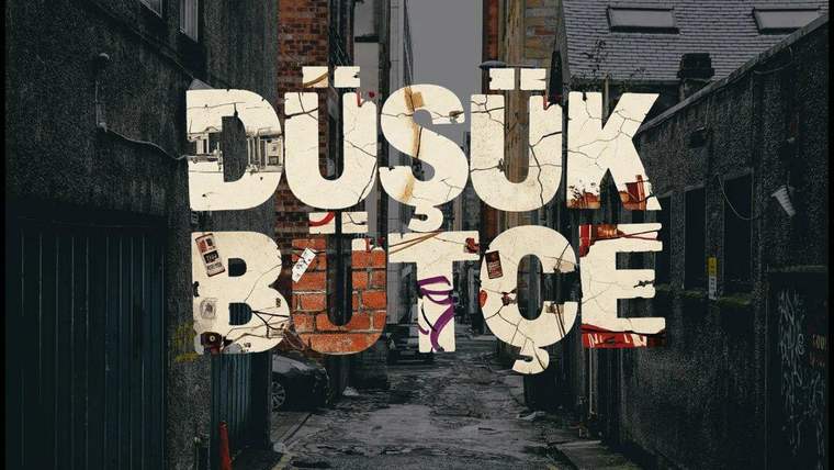Dar ve karanlık bir ara sokak üzerinde, büyük harflerle “DÜŞÜK BÜTÇE” yazısı ve kolaj görselleri yer alıyor.