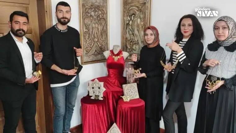 Divriği Ulu Cami motifli takıların sergilendiği bir alanda, beş kişi takıları tutarak poz veriyor.