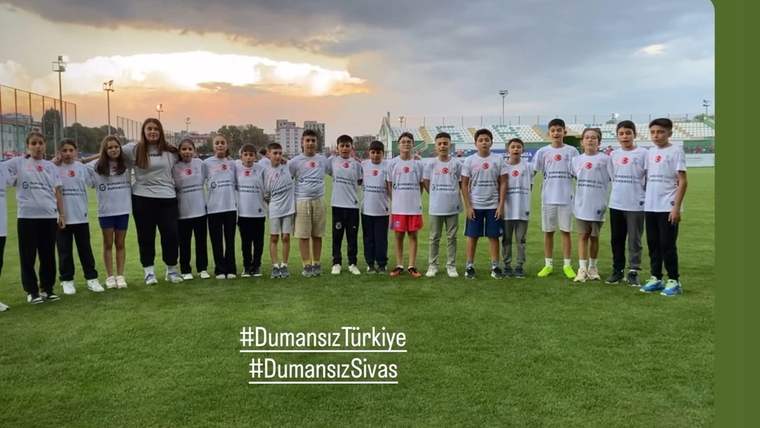 Dumansız Sivas etkinliği için bir araya gelen çocuklar, futbol sahasında sırayla duruyor.