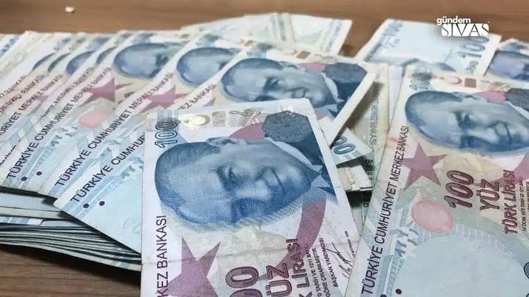 Üzerinde Atatürk resmi bulunan 100 TL banknotlar, masanın üzerinde bir araya getirilmiş.