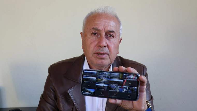 Bir kişi, akıllı telefonunda güvenlik kamerası görüntülerini gösteriyor.