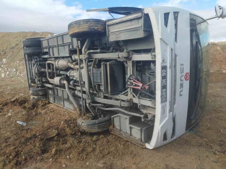 Toprak zeminde yan yatmış beyaz bir araç ve aracın açıkta kalan alt bölümü görülüyor.