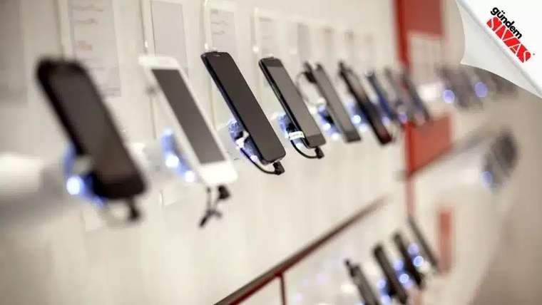 Bir mağazada sergilenen çeşitli akıllı telefonlar, raf üzerinde sıralanmış.
