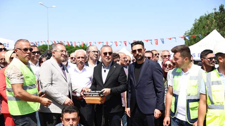 Açık havuz projesinin başlangıç töreninde bir grup insan, sahnede duruyor.