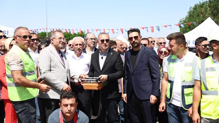 Açık havuz projesinin başlangıç töreninde bir grup insan, sahnede duruyor.