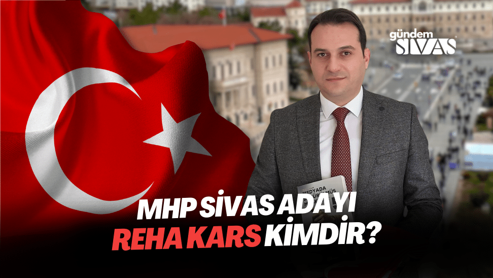 Arka planda Türk bayrağı bulunan bir kişi, elinde not defteri tutarak kameraya bakıyor.