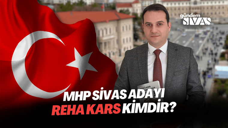Arka planda Türk bayrağı bulunan bir kişi, elinde not defteri tutarak kameraya bakıyor.