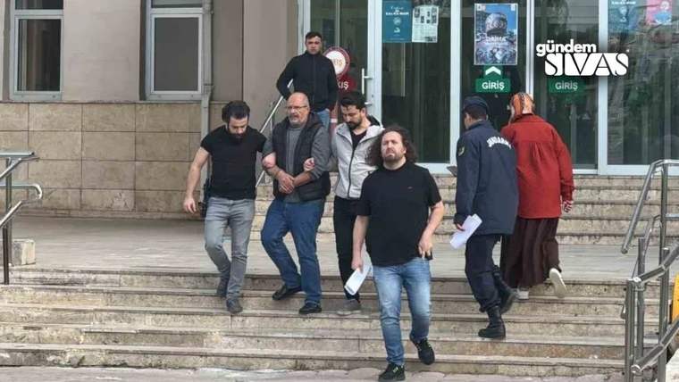 Bir binanın giriş merdivenlerinde, birkaç erkek ve iki kişinin birlikte aşağı indiği görülüyor.