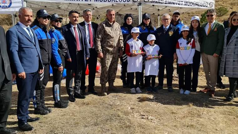 “Sivas Emniyet Müdürlüğü” yazılı çadır önünde polis üniformalı kişiler, çocuklar ve yetişkinler birlikte duruyor.