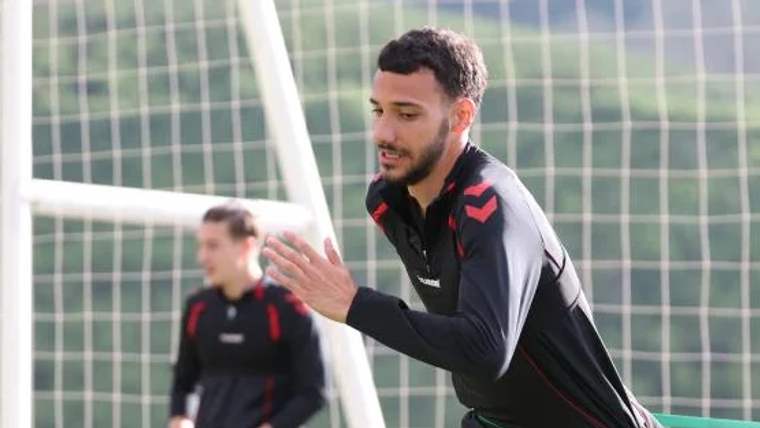 Antrenman yapan futbolcu, kaleye doğru koşuyor; arka planda başka bir oyuncu var.