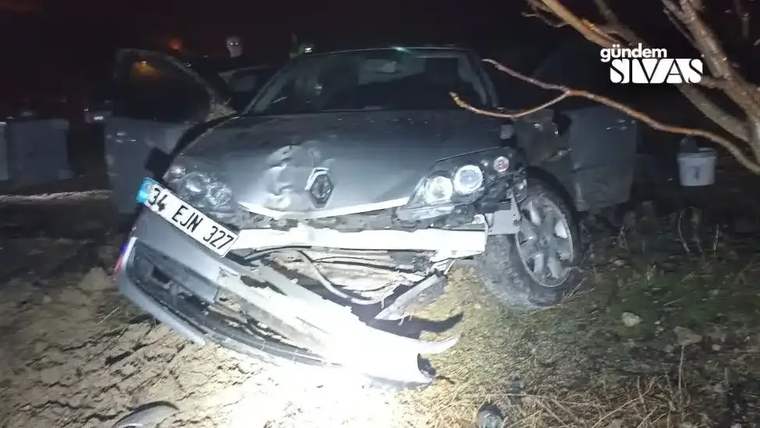 Kaygan yolda kaza yapan gümüş renkli bir otomobil, yol kenarında hasar görmüş şekilde duruyor.