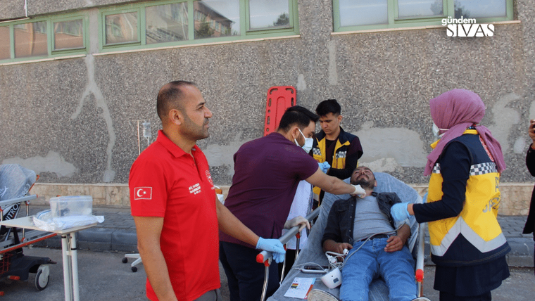 Bir sağlık tatbikatında, yaralı bir kişi sedyede yatarken sağlık ekipleri müdahale ediyor.