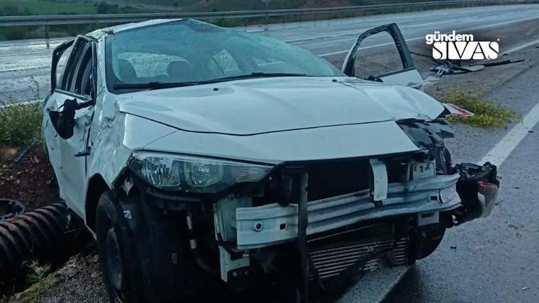 Yolda devrilmiş beyaz bir araç, ön kısmında hasar var.