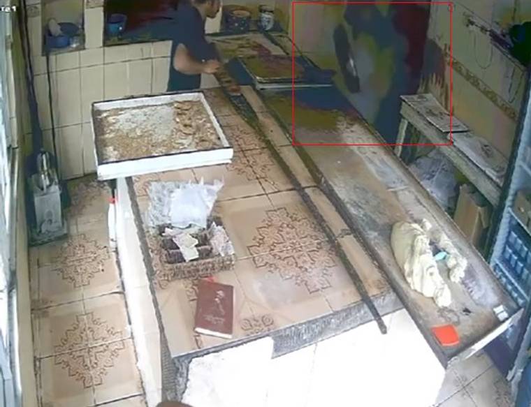 Tezgâhların bulunduğu dükkânda iki kişi görülüyor; biri önde dururken diğeri arka tarafta yer alıyor.
