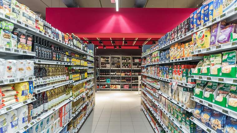 Süpermarketin raflarında süt ürünleri, içecekler ve çeşitli ambalajlı gıdalar sıralanıyor.