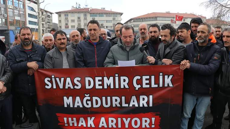 Kalabalık bir grup, "Sivas Demir Çelik Mağdurları Hak Arıyor!" yazılı pankart tutuyor.