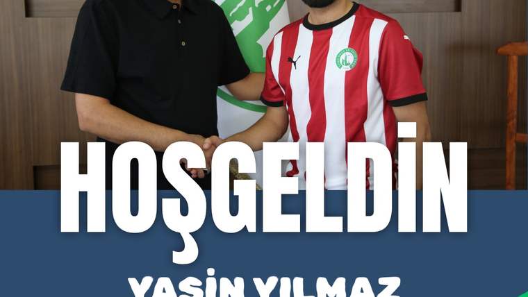 Bir futbolcu, kulüp yetkilisiyle birlikte poz veriyor; futbolcu, kırmızı-beyaz formasıyla görünüyor.