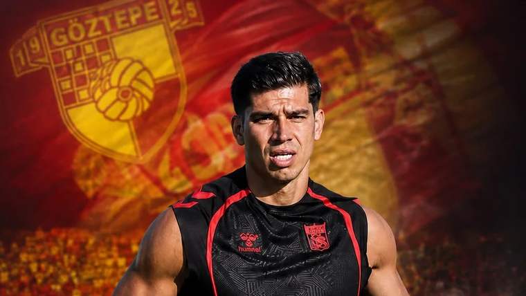 Göztepe forması giymiş bir futbolcu, arka planda Göztepe logosu ve takım renkleriyle poz veriyor.