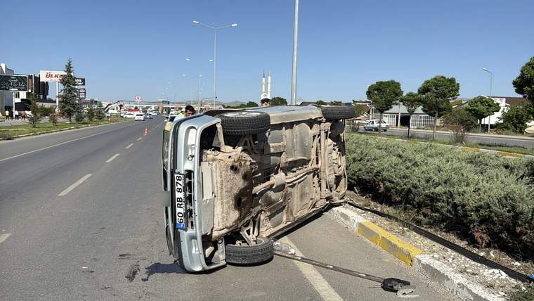 Bölünmüş yolun kenarında yan yatmış, alt kısmı görünen beyaz bir araç ve çevresinde dağılan parçalar