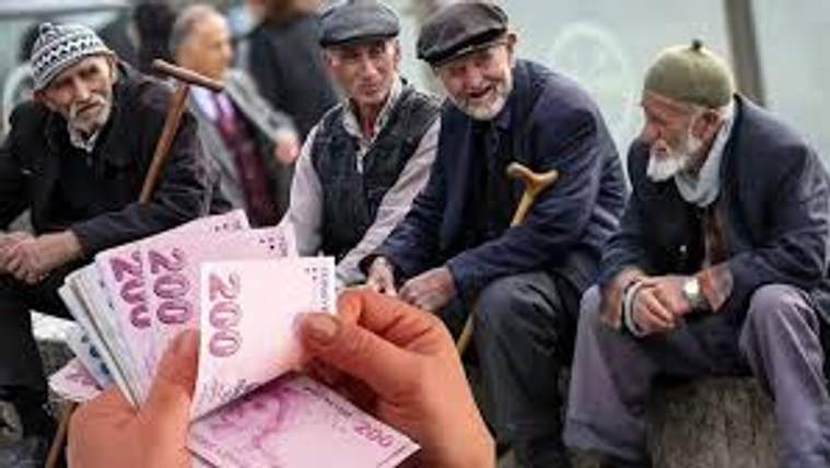 Bir kişinin elinde 200 TL banknotlar var, arka planda birkaç yaşlı erkek oturuyor.