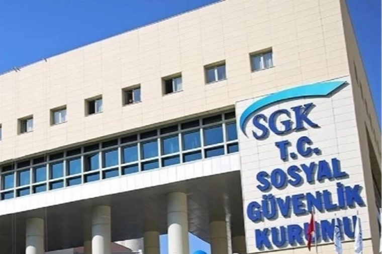 Üzerinde “SGK T.C. Sosyal Güvenlik Kurumu” yazan tabela, kurumsal bir binanın ön cephesinde görülüyor.