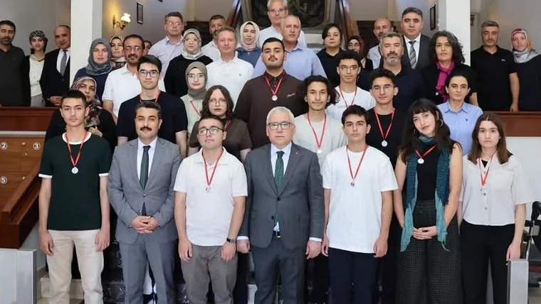 Sivas Valiliği'nde YKS şampiyonları ve yetkililer bir arada, madalyalar takılı.