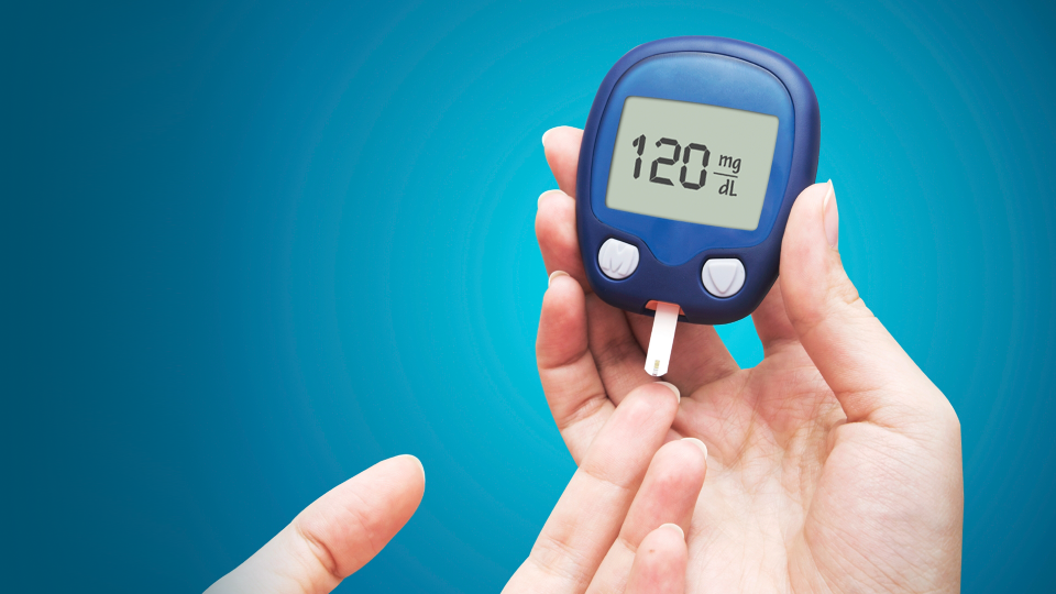 Bir el, kan şekeri ölçüm cihazının ekranında 120 mg/dL değerini gösteriyor.