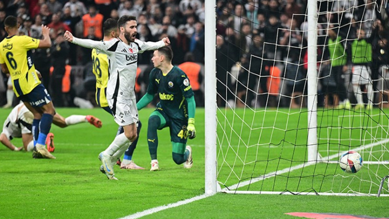 Beşiktaş oyuncusu, Fenerbahçe kalesine gol attıktan sonra sevinçle kollarını açmış. Kaleci yerde.