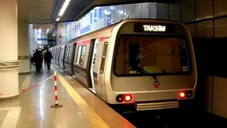 Taksim metro istasyonunda duraklamış bir metro aracı, istasyon içinde bekliyor.