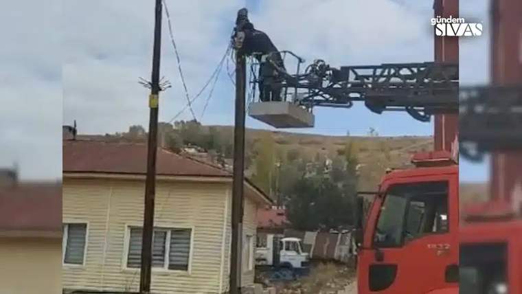 İtfaiye aracının merdiveni, elektrik direğine uzanmış bir kişi ile birlikte görünmektedir.