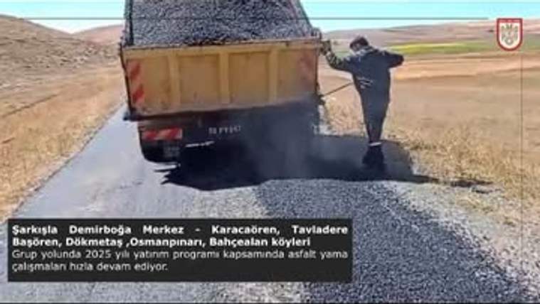 Asfalt yama çalışması yapan bir kamyon, grup yoluna malzeme döküyor.