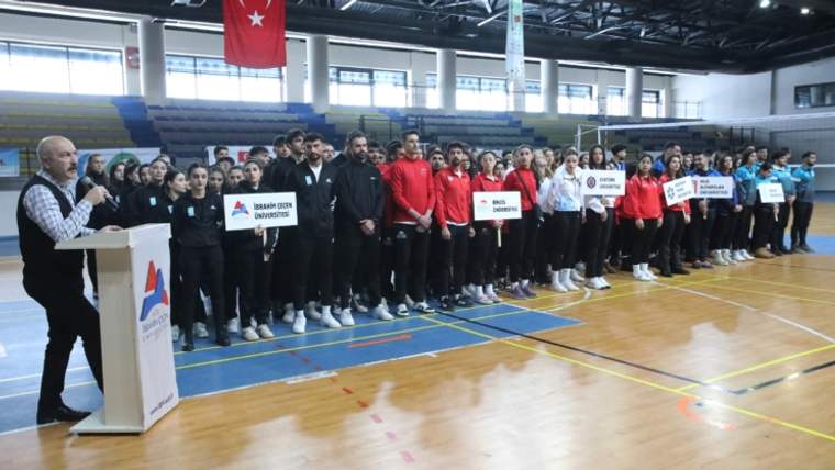 Voleybol müsabakaları için toplanan sporcular, salon içinde sıralanmış halde duruyor.