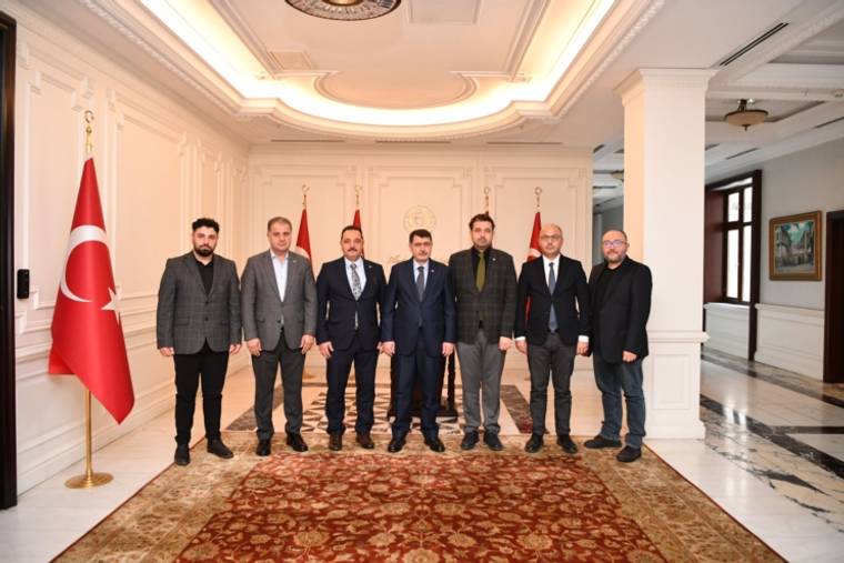 Ankara Valisi Şahin ile birlikte duran sekiz kişi, arka planda Türk bayrağı ve diğer bayraklar var.