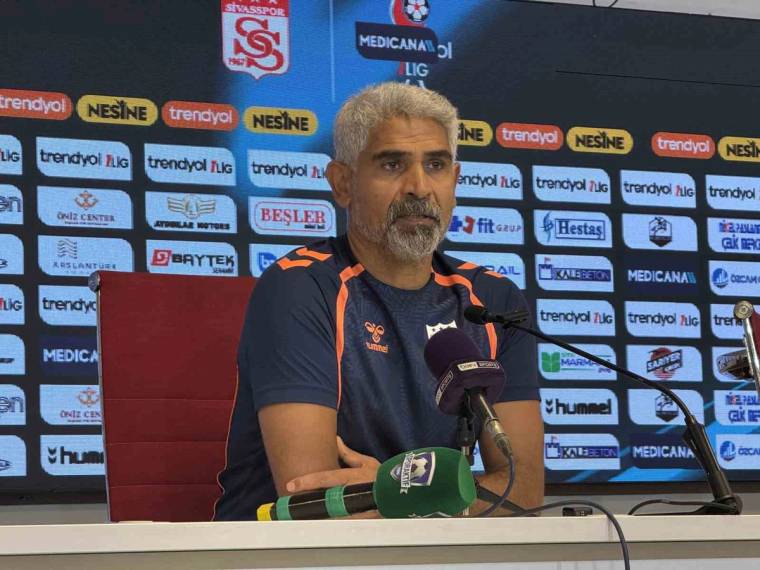 Sivasspor armalı sponsorluk panosu önünde, mikrofonların arkasında oturan sakallı bir kişi