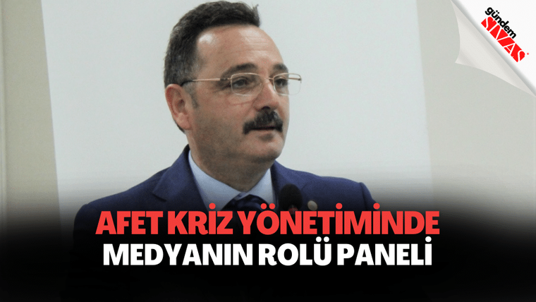 Kürsüde konuşan bir kişi, arka planda "Afet Kriz Yönetiminde Medyanın Rolü Paneli" yazılı bir pankart var.