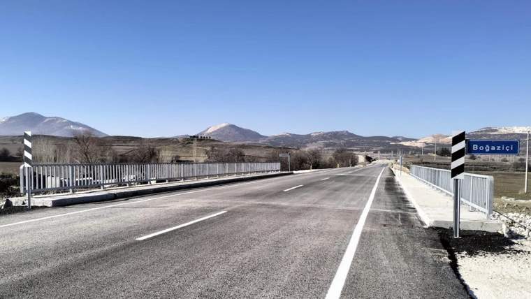 Boğaziçi yazılı tabelanın bulunduğu, dağlık arazide uzanan asfaltlı köprü yolu