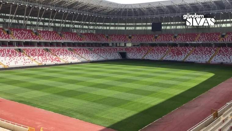 Sivas'taki stadyumun içi, yeşil futbol sahası ve tribünler görünmekte.