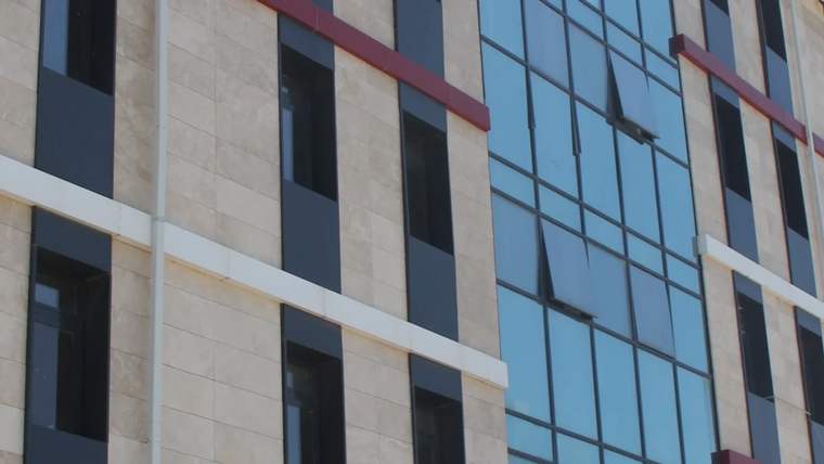 Yeni kamp merkezi binasının dış cephesi, cam ve taş kaplama ile tasarlanmış.