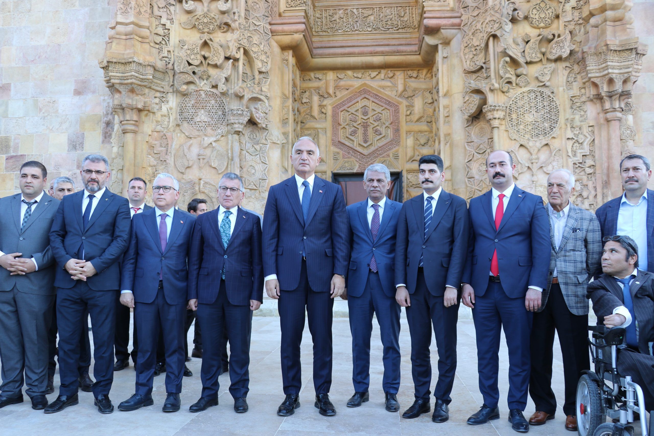 Divriği Ulu Cami önünde, bakan ve yanındaki kişiler poz veriyor.
