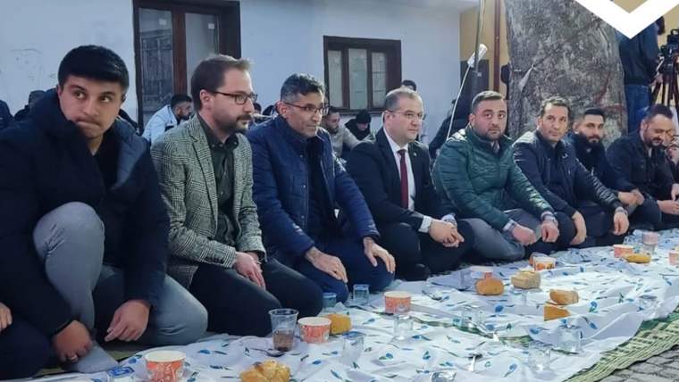 İftar sofrasında oturan insanlar, önlerinde yiyecek ve içecekler var.