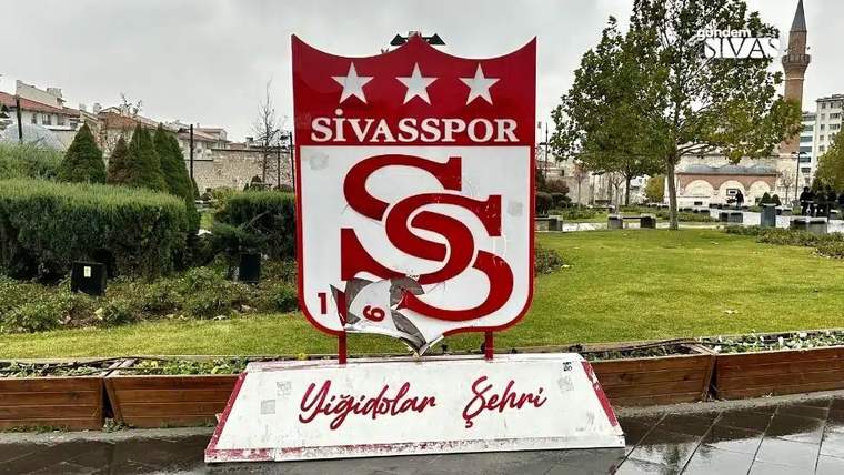 Sivasspor yazılı kırmızı-beyaz arma tabelasının alt bölümünde kopmuş ve parçalanmış yüzey görülüyor.