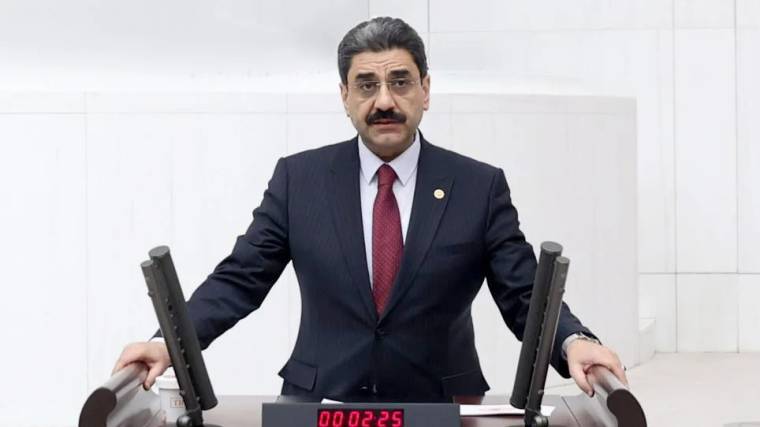 Kürsüde konuşan bir kişi, önünde zaman sayacı var.